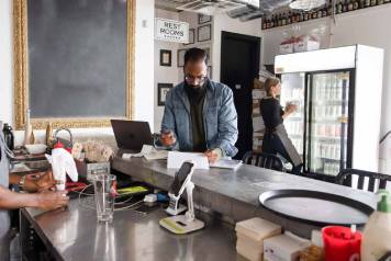 Propietario de una tienda haciendo trabajo administrativo en el mostrador