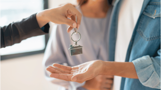 Agente inmobiliario entregando las llaves de una casa a su cliente.