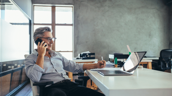 Fundador de una empresa emergente en la oficina hablando por teléfono