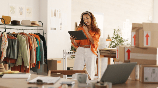 Comercio electrónico, propietario de pequeña empresa con tableta tomando pedidos de venta y comprobando el inventario.