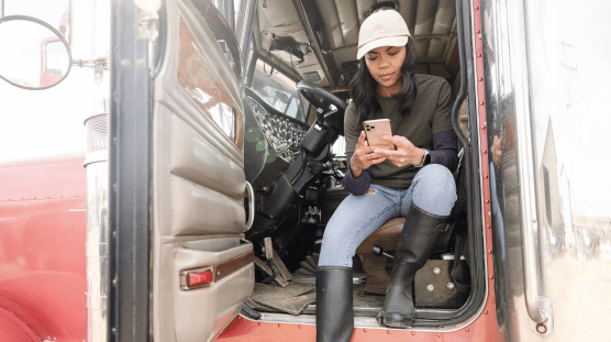 Una camionera registra sus millas en su teléfono móvil