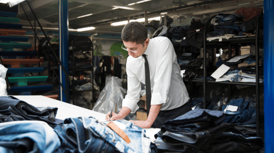 Denim jeans designer taking notes on their latest design.