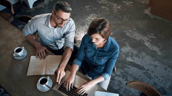 Restaurant owner and their new employee enjoying coffee while going over onboarding documents.