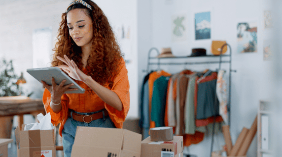 Clothing boutique owner checks inventory on her tablet.