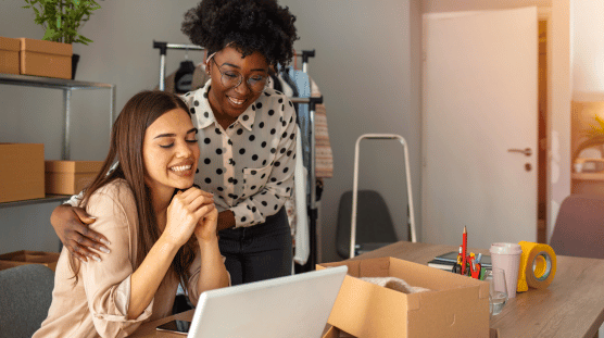 The Right Time to Give out Raises and Bonuses Female e-commerce business owner giving a pat on the back to a colleague for a job well done.