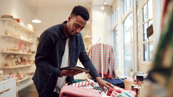 Male small business owner checks stock in shop using digital tablet