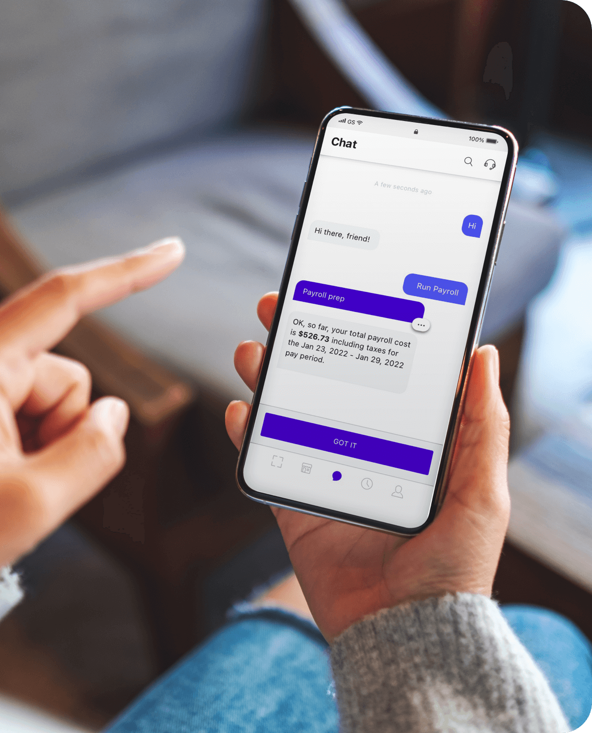 Mobile phone in person's hand open to Roll app with payroll notification overlay