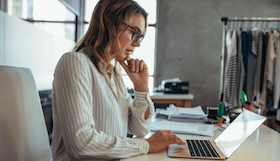 Woman reviews tax documents on computer.