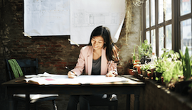 Una mujer sonríe mientras revisa los planes empresariales.
