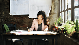 Woman smiles while reviewing business plans.